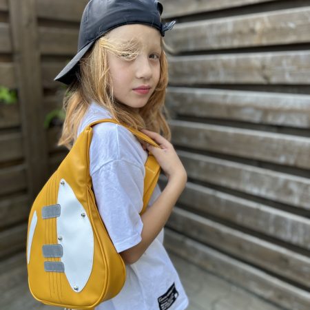 tiny-riff-rucsac-gradinita-chitara-galbena Tiny Riff – copil purtând rucsac galben chitară pentru grădiniță