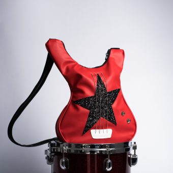 Victory Star este o geantă roșie în formă de chitară inspirată din bass-ul Victoriei de la Måneskin, decorată cu o stea mare strălucitoare și corzi reale de chitară realizată manual din piele eco italiană premium. Un accesoriu cu spirit rock, ideal pentru concerte, festivaluri și ținute de zi cu zi care ies în evidență.